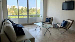 Interior de departamento Kabah 507: estancia con sofá y vista exterior, Vidanta, Acapulco, Guerrero, México
